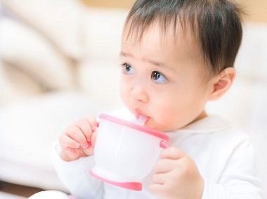 赤ちゃんがミルクをストローで飲む